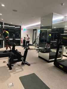 悉尼Prestige Hyde Park Studio Apartment的健身房,有跑步机和椭圆机的人在健身