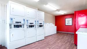 蒙哥马利Home 1 Suites Extended Stay的洗衣房配有白色的洗涤器和红色的墙壁