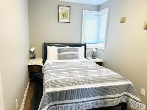 滨湖尼亚加拉Cozy 3-bedroom farmhouse in wine-country的一间卧室配有一张床,床上有条纹毯子