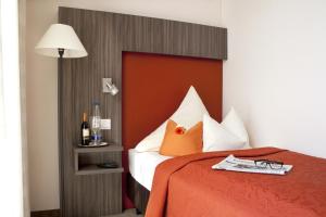 埃尔丁林奈酒店的一间卧室配有一张红色床头板的床