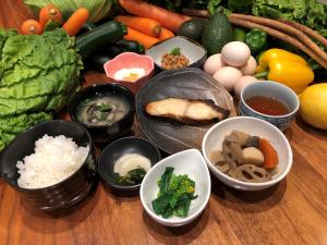 出云市Green Rich Hotel Izumo (Artificial hot spring Futamata Yunohana)的桌子上放着各种蔬菜碗