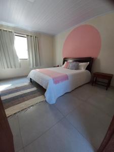 佩尼多Chalé Penedo Charmosa的一间卧室配有一张带粉红色床头板的大床