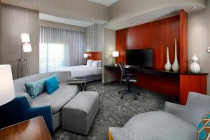 圣安东尼奥圣安东尼奥六旗游乐园瑞姆购物中心万怡酒店的配有一张床和一张书桌的酒店客房