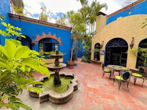 瓜达拉哈拉恩斯韦诺别墅精品酒店的庭院设有喷泉和蓝色建筑