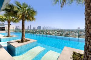 迪拜Element Al Mina, Dubai Jumeirah的一座棕榈树游泳池,位于一座建筑的顶部