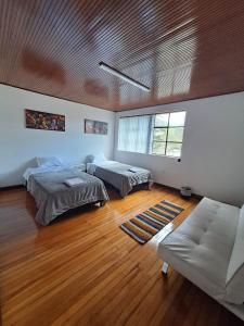 波哥大Makarena Hostel的一间带两张床和一张沙发的客厅