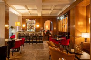 佛罗伦萨西纳维拉美迪齐傲途格精选酒店的一间设有红色椅子的餐厅和一间酒吧