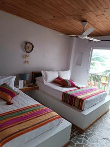 RincónHotel Casa Sattva- Bed & Breakfast的卧室内两张并排的床