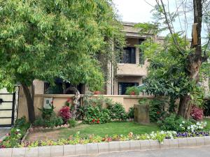 伊斯兰堡Riviera Courtyard Guest House Islamabad的鲜花屋前的花园