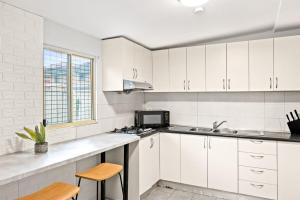 悉尼Signature Double Room in Auburn的白色的厨房配有水槽和微波炉