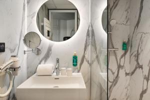 瓦讷Hôtel & Spa Le Maury, Vannes, The Originals Boutique的浴室配有盥洗盆和带镜子的淋浴