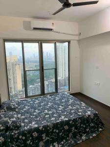 孟买Room in Flat with Amazing City and Sea View的一间设有床铺的卧室,位于带窗户的房间内