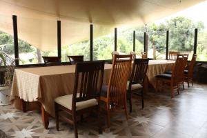 纳库鲁Brooks Lodge的一间带桌椅和窗户的用餐室