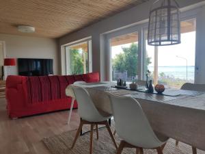 科尔莫登Villa Kolmården的一间带桌子和红色沙发的用餐室