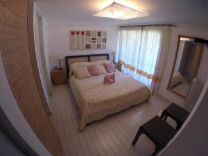马里纳·迪·波迪斯科Luxury Apartment Sardegna的一间小卧室,配有一张床和镜子