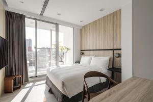 台中市一期家旅的一间卧室设有一张床和一个大窗户