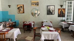 艾兹鲁Hotel des cedres,azrou maroc的用餐室配有桌子和白色的桌椅