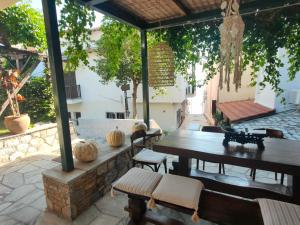 阿吉奥斯伊欧尼斯Galini Hotel Agios Ioannis Pelion的户外庭院配有木桌和椅子