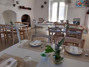 滨海波利尼亚诺Masseria San Martino的用餐室配有白色的桌子和木椅