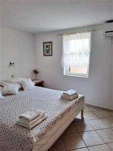 诺瓦利娅TEODORA - kamenný domek 300 m od moře的一间卧室配有带毛巾的床