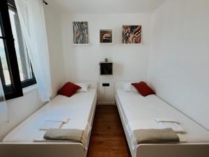 西利皮Dawn & Dusk - Modern Two Bedroom Apartment with Mountain Views的配有2张床的白色墙壁和窗户客房