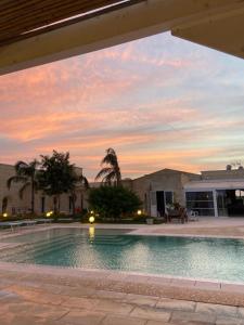 纳尔多PODERE CARAFA的一座享有日落美景的建筑前的游泳池