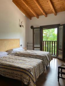 LuquianoApartamentos Rurales Casa Lafuente的带阳台的卧室内的两张床