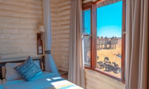 TsavoSalt Lick Safari Lodge的一间卧室设有一张床和一个大窗户