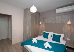 比托拉ZARO Apartments的一间卧室配有一张带蓝白色枕头的大床
