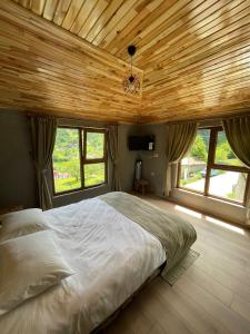 特拉布宗Bizim O'ra Küme Evleri & Bungalov的一间卧室设有一张带木制天花板的大床