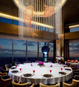 上海上海浦东丽思卡尔顿酒店的一张大桌子,位于一个配有大吊灯的房间