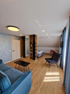 尤尔巴尔卡斯Editos apartamentai的客厅配有蓝色的沙发和桌子