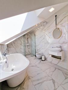 尤尔巴尔卡斯Editos apartamentai的浴室配有白色浴缸和水槽