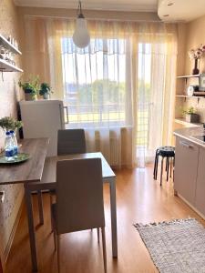 里加Apartment Saharova的厨房以及带桌椅的用餐室。