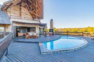 马布拉Kubu Lodge的一个带游泳池和房子的甲板