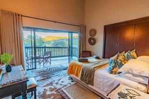 马布拉Kubu Lodge的一间卧室设有一张床和一个阳台