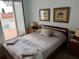 萨洛Casa la Pineda Salou, playa y Port Aventura的一间卧室设有一张床和一个大窗户