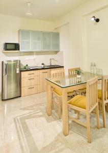 OxelFig House Anjuna-Chapora Road , Siolim 1BHK Suite的厨房配有桌椅和冰箱。