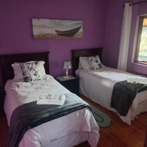 KingsboroughGuest house Winklespruit的紫色墙壁客房的两张床
