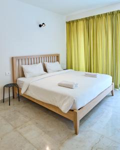 OxelFig House Anjuna-Chapora Road , Siolim 1BHK Suite的一间卧室配有一张带白色床单的大床