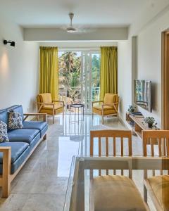 OxelFig House Anjuna-Chapora Road , Siolim 1BHK Suite的客厅配有蓝色的沙发和椅子