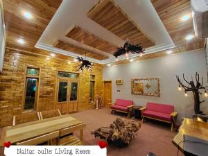 吉尔吉特Das-e-Basi的客厅设有木制天花板和红色椅子