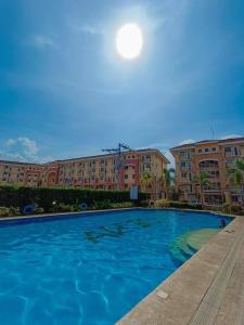达沃市Arezzo Place Davao Condominium的大楼前的大型蓝色游泳池