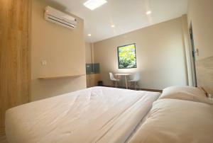 Xuyên MộcZEN garden的卧室配有一张白色的大床和一张桌子