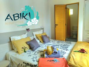 阿尔比恩Maya-Abiki Mauritius的卧室配有两张床,墙上有标志