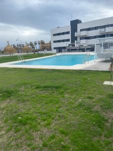贝莱斯Valleniza ViaCelere 2 dormitorios的大楼前的大型游泳池