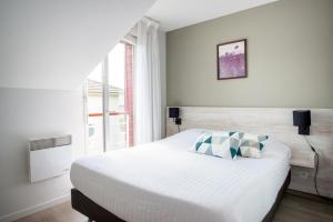 南特南特-贝奥约泽尼图德公寓式酒店的一间卧室设有一张大床和一个窗户。