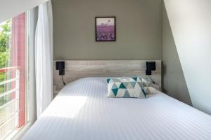 南特南特-贝奥约泽尼图德公寓式酒店的卧室配有白色的床和窗户