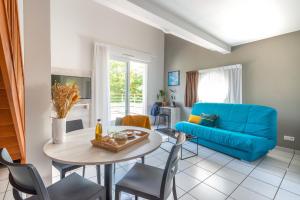 南特南特-贝奥约泽尼图德公寓式酒店的客厅配有蓝色的沙发和桌子