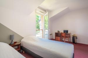 南特南特-贝奥约泽尼图德公寓式酒店的一间卧室配有一张床、一张书桌和一个窗户。